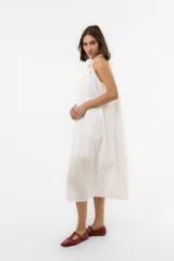 Vestido midi celeste de calce amplio y liviano, con escote fruncido regulable y breteles finos con detalles de cuentas. Presenta una silueta suelta e incluye una mini cartera desmontable al tono.