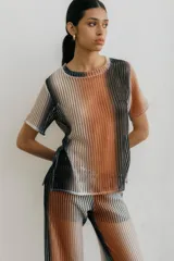 Remera de red con diseño de rayas verticales en tonos degradados de blanco, negro y naranja. Presenta cuello redondo y mangas cortas, con una textura calada y transparente.