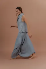 Pollera larga de lino color gris topo, de diseño amplio con volumen, movimiento y bolsillos delanteros. Cuenta con elástico en la cintura y detalles de pinzas y sobretelas en los laterales.