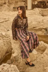 Camisa de satén color negro con acabado brillante, cuello en V, cierre frontal con botones de nácar y diseño ajustable con cordones laterales para fruncir.