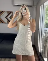 Vestido corto marrón con estampado de flores blancas, escote en V y tirantes finos.