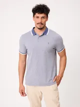 Remera polo de piqué de algodón melange color celeste, con cuello y puños en contraste blanco y azul, cierre frontal con botones y bordado pequeño en el pecho.