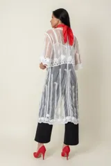 Túnica blanca de tul bordada en hilo, con mangas cortas y terminación de blonda bordada.