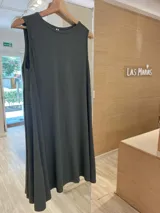 Vestido corto sin mangas, color verde oscuro, confeccionado en tejido de punto acanalado, con corte amplio y ruedo asimétrico.