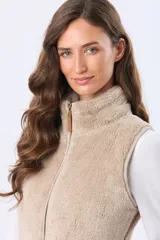 Chaleco de tejido sherpa color crema, con cierre frontal y detalles de terminación en eco cuero color tostado.