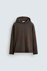 Sudadera tipo hoodie de corte relajado, confeccionada en tejido de algodón con interior de rizo. Presenta cuello con capucha, manga larga y acabados con bordes enrollados.