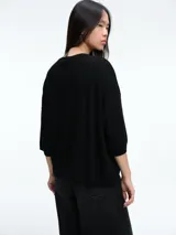 Sweater de tejido de punto en color gris, con cuello redondo y mangas tres cuartos de corte holgado.