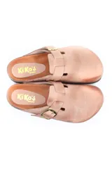 Zueco de cuero color beige con diseño de punta cerrada, ajuste mediante hebilla metálica dorada en el empeine y suela de corcho con base de goma.