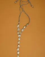 Collar artesanal compuesto por piezas irregulares de alpaca unidas por eslabones, con cordón de algodón natural regulable que permite ajustar el largo.