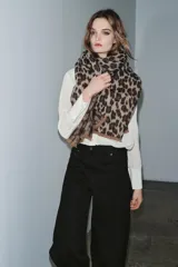 Pañuelo rectangular de tejido jacquard con estampado animal print en tonos marrones y beige, con terminaciones deshilachadas en los extremos.