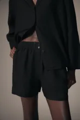Shorts de tiro medio confeccionados en lino, con cintura elástica y bolsillos laterales ocultos en costura.