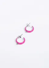 Par de aros tipo argolla de acero quirúrgico color fucsia, con un strass incrustado.