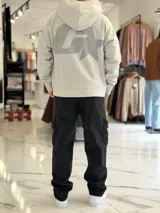 Canguro oversize gris con capucha y gran estampado gráfico trasero en tono más oscuro.