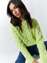 Sweater color crema tramado de manga larga y cuello redondo.