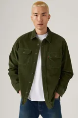 Camisa de pana color verde militar, con cuello clásico, cierre de botones frontales y dos bolsillos con solapa en el pecho.