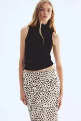 Pollera midi de corte evasé con caída fluida y acabado satinado. Presenta un estampado de leopardo en tonos neutros y cintura elástica para un ajuste cómodo.