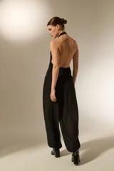 Pantalón tipo babucha de color negro, confeccionado en tela semitransparente con textura de rayas verticales y pequeños detalles en relieve. Presenta una cintura elástica cómoda y un corte holgado que se ajusta ligeramente en los tobillos.