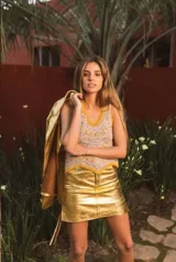 Minifalda de tiro medio y corte recto en color dorado metalizado, con cierre frontal y bolsillos.