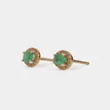 Aros tipo caravana de oro 18k con esmeralda central en corte ovalado rodeada por un halo de brillantes.