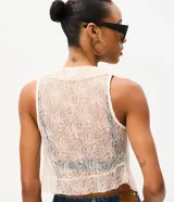Blusa de poliamida color beige con encaje delicado, diseño sin mangas, escote en V con volados y cordones frontales para atar.