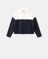 Jersey de punto de manga larga, con diseño bicolor en blanco y negro, cuello alto con cierre de cremallera corta.