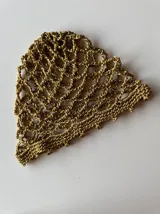 Casquete tejido a crochet en hilo metalizado color gris plata, con diseño calado.