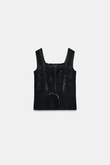 Top negro de escote cuadrado y tirantes anchos, con detalle de bordados florales y puntilla combinada a tono. Presenta una cintura ajustable con lazo frontal.