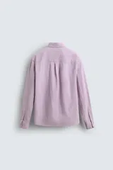 Camisa de corte regular fit confeccionada en tejido de algodón con textura. Presenta cuello solapa, cierre frontal de botones, manga larga con puños abotonados y un bolsillo plastrón en el pecho.