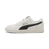 Championes urbanos Puma modelo Majesty, color beige con franja lateral característica en negro y detalle de firma en el lateral. Presenta suela de goma con textura y perforaciones en la puntera para mayor ventilación.