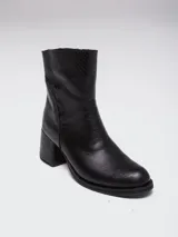 Botas de caña baja en cuero color marrón oscuro, con taco cuadrado y punta redondeada. Presentan un diseño tipo western con estribo desmontable que incluye una hebilla metálica decorativa.
