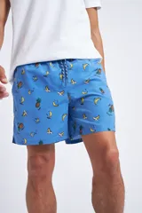 Short de baño con cintura elástica y cordón ajustable, confeccionado en tela ligera de secado rápido. Presenta un estampado botánico integral en tonos amarillos, blancos y azules, con dos bolsillos delanteros y uno posterior.