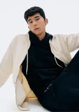 Buzo con capucha de corte clásico, confeccionado en tejido de algodón, con bolsillo frontal tipo canguro y puños acanalados.