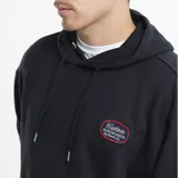 Canguro con capucha y cordones ajustables, color verde grisáceo. Presenta un bolsillo frontal tipo canguro y un parche bordado en el pecho con diseño de marca. Posee puños y ruedo acanalados.