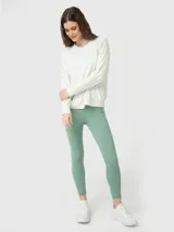 Polera de manga larga en color blanco hueso, confeccionada en tejido suave y ligero. Presenta cuello redondo, puños elásticos y ajuste en la cintura, con un pequeño logo bordado en el pecho.