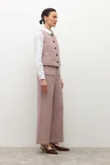 Pantalón tipo culotte de tiro alto con estampado de cuadros pequeños en tonos beige y marrón. Presenta bolsillos frontales tipo parche y corte recto de pierna ancha.