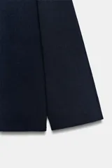 Jersey de punto de color azul marino, con cuello subido y manga larga de corte holgado.
