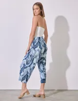 Pantalón capri de satén plisado con estampado abstracto en tonos azules y blancos, pretina ancha elastizada.