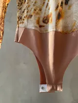 Body de tul ajustado con estampado animal print, escote redondo y mangas largas.