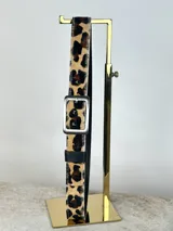 Cinturón de cuero con estampado animal print, hebilla cuadrada plateada y reverso negro.