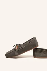 Mocasín estilo náutico de gamuza marrón, con cordones de cuero, borla decorativa y cuentas de colores en el empeine.