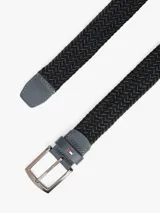 Cinturón trenzado elástico de color negro, con hebilla metálica cuadrada de acabado oscuro y trabilla de cuero sintético gris con el logo de Tommy Hilfiger.