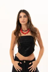 Top strapless de cuerina negra con diseño estilo corset y terminación en punta en la parte frontal. Cuenta con cierre en la parte posterior.