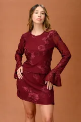 Falda corta de encaje color bordó con diseño floral en relieve, de corte recto y estilo femenino.