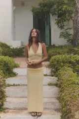 Falda midi de tiro medio, confeccionada en tejido semitransparente color amarillo con estampado de lunares diminutos en tono rosado. Cuenta con cintura elástica y forro interior a tono.