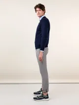 Pantalón chino azul marino de corte slim fit, confeccionado en gabardina con 77% algodón, 20% de algodón reciclado y 3% elastano. Presenta bolsillos delanteros y traseros. Tiene un lavado final con enzima ácida que le da un aspecto desgastado.