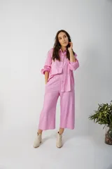 Pantalón de pierna ancha con estampado de hojas en tonos amarillos y marrones, cintura elastizada y bolsillos laterales.