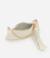Cartera shoulder de poliuretano color crema, con asa corta de mano y asa larga de cadena dorada, ambas removibles. Incluye cierre de cremallera y borla decorativa.