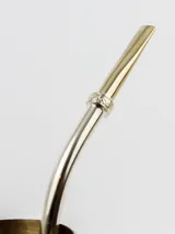 Bombilla para mate de acero inoxidable con detalles dorados y anillo decorativo con diseño floral.