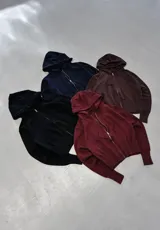 Campera tipo hoodie de tejido de punto, color marrón oscuro, con cierre frontal completo, capucha con cordones ajustables y puños y ruedo acanalados.
