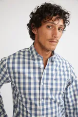 Camisa de manga larga con cuello clásico y cierre frontal abotonado. Presenta un estampado de cuadros en tonos azul marino y rojo. Confeccionada en algodón, cuenta con un corte slim fit y logo bordado en el pecho.